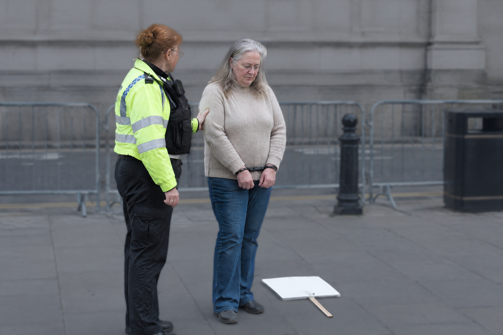 Police officer holding handcuffed woman Arrested at a protest