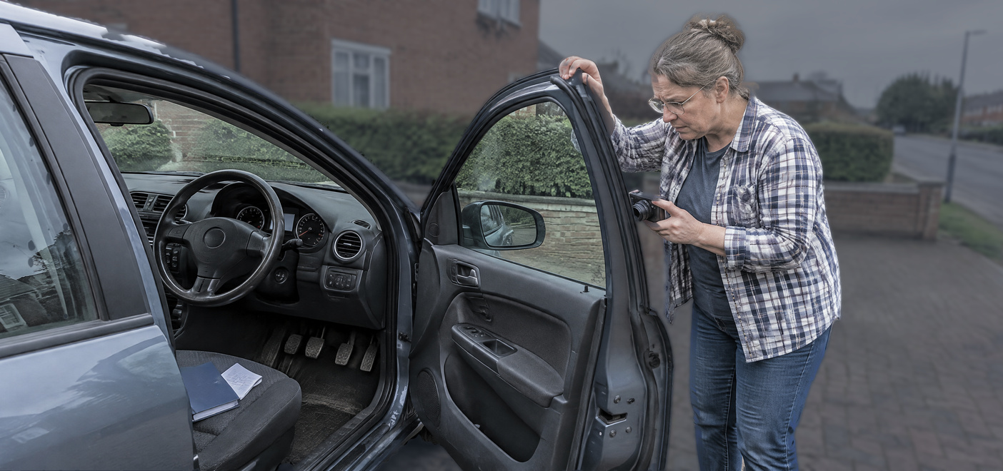 Woman inspecting a used car after a Car Fraud allegation