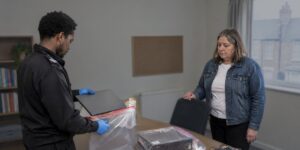 Police officer bagging devices as evidence in malware charges investigation