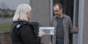 Officer showing a bagged phone to a man over a non-molestation order
